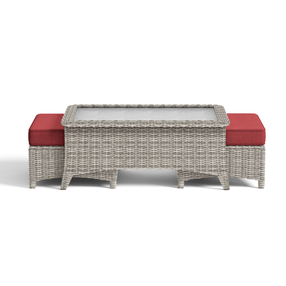 Wicker outdoor table with red cushions on a white background
