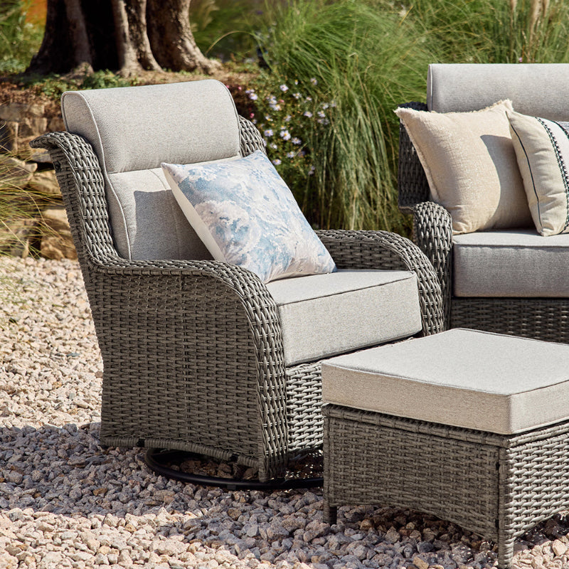 Outdoor wicker furniture set with cushions on a pebbled surface