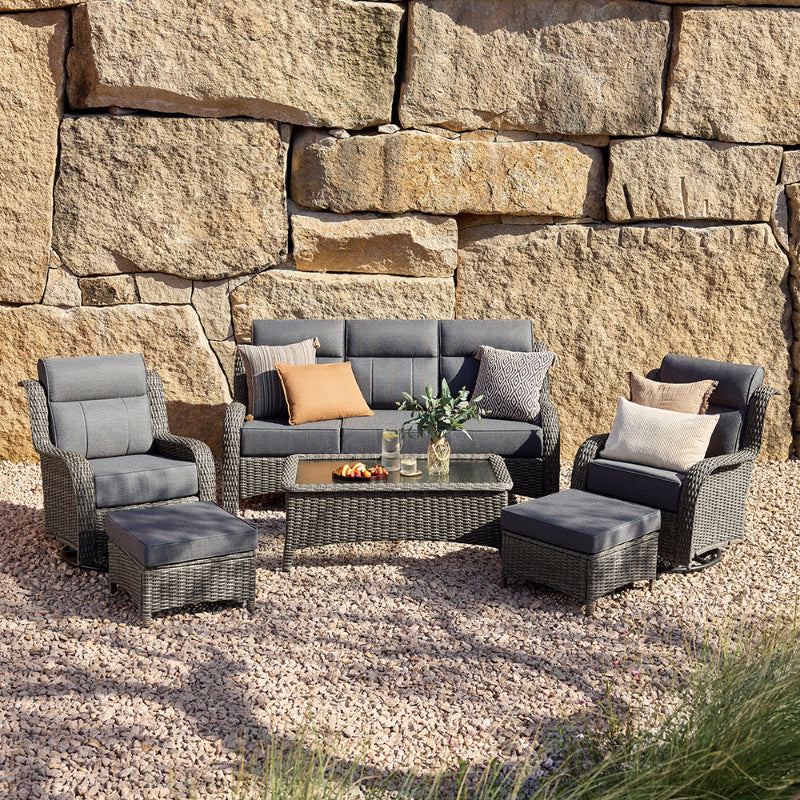 Outdoor patio furniture set against a stone wall.