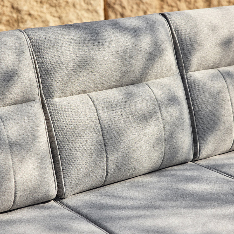 Gray outdoor sofa with a textured surface on a stone background