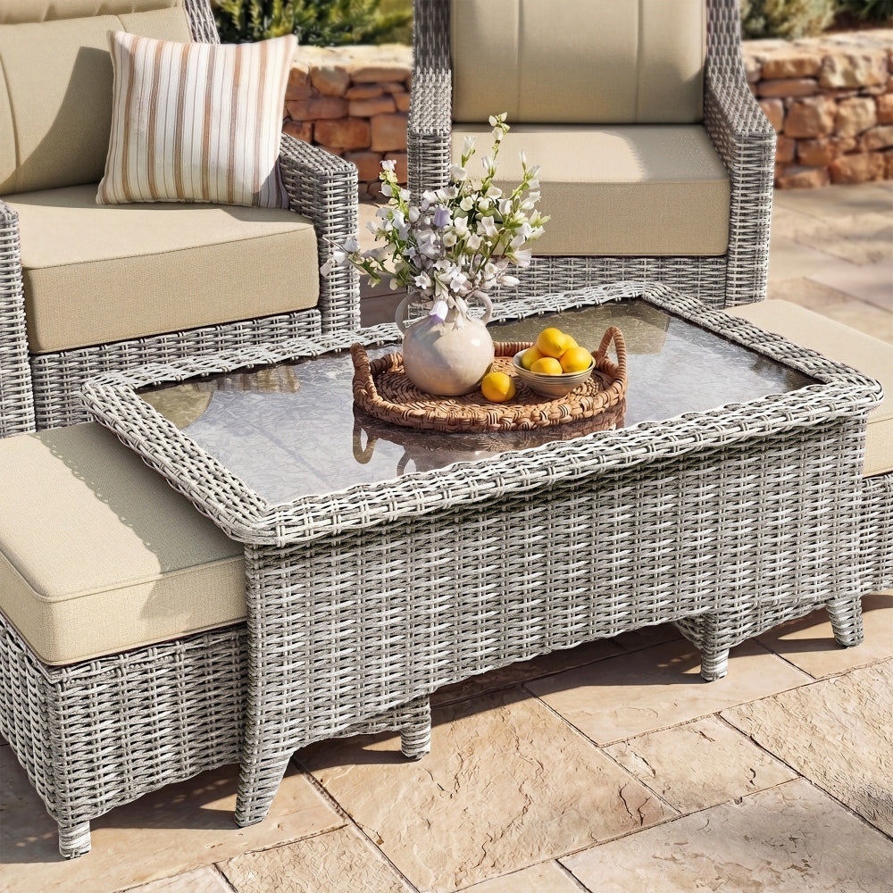 Outdoor patio furniture set with wicker chairs and table on a stone patio.