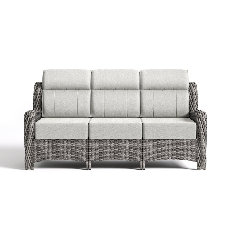 Gray wicker outdoor sofa with light gray cushions on a white background