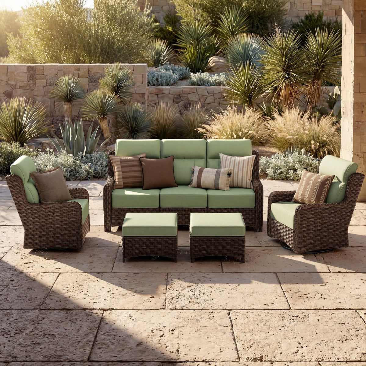 Outdoor patio furniture set with green cushions on a stone patio