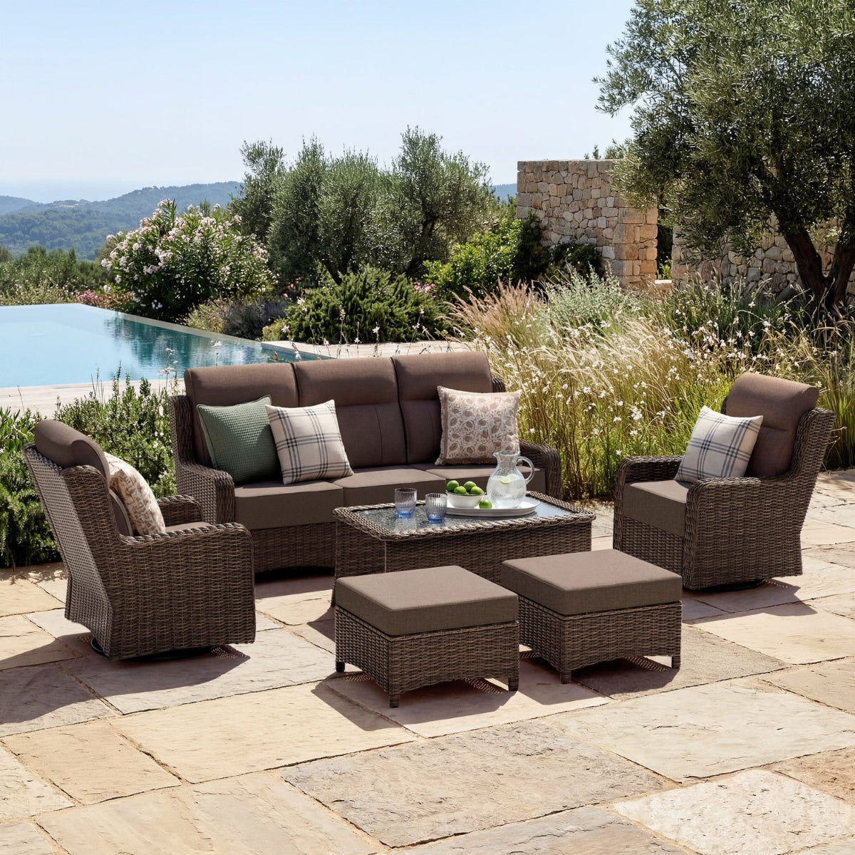 Outdoor patio furniture set with cushions near a pool and garden.