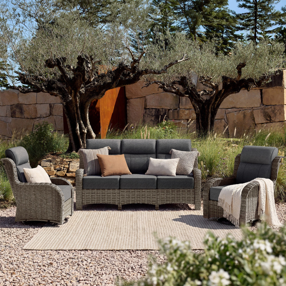 Outdoor patio furniture set with gray cushions in a garden setting.