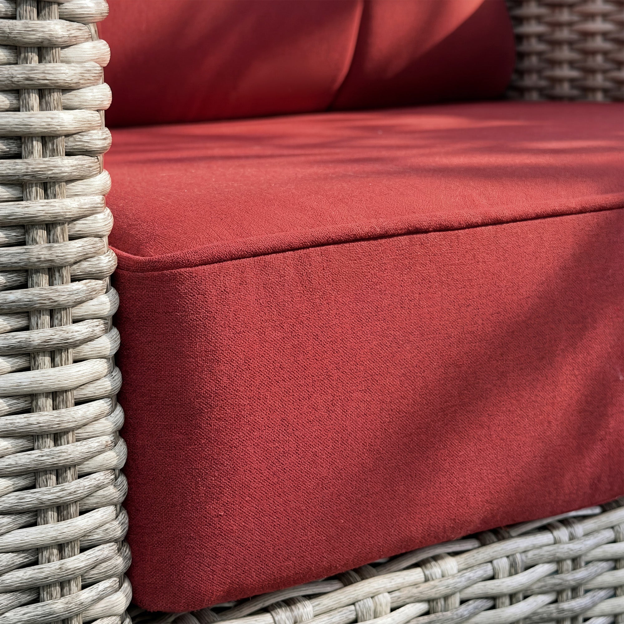 Close-up of a red cushion on a wicker chair