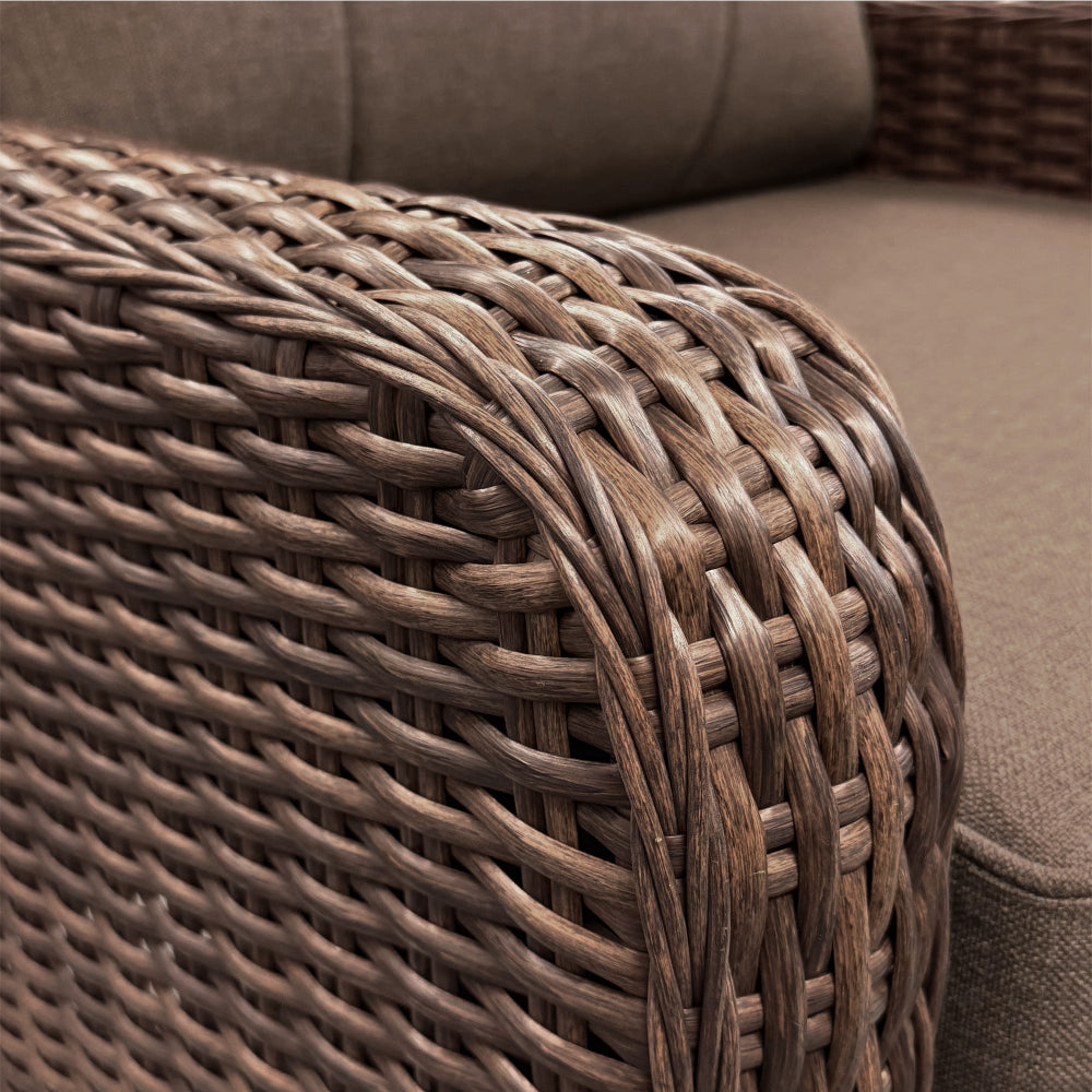Close-up of a woven brown ottoman next to a textured brown sofa.